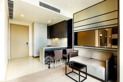 Modern living room with sleek design and open kitchen layout in a stylish apartment.