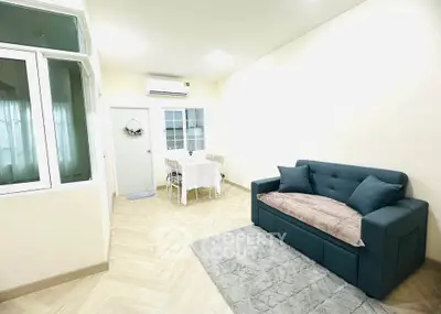 Charming living room with cozy sofa and dining area, perfect for modern living.