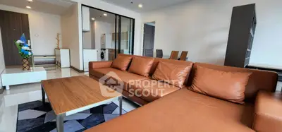 Spacious living room with modern brown leather sofa and stylish wooden table