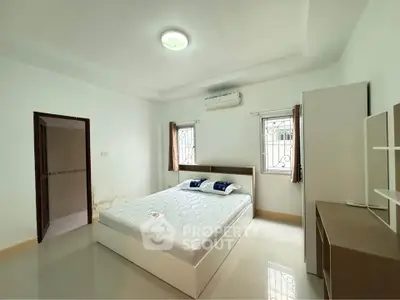 Spacious bedroom with modern furnishings and natural light