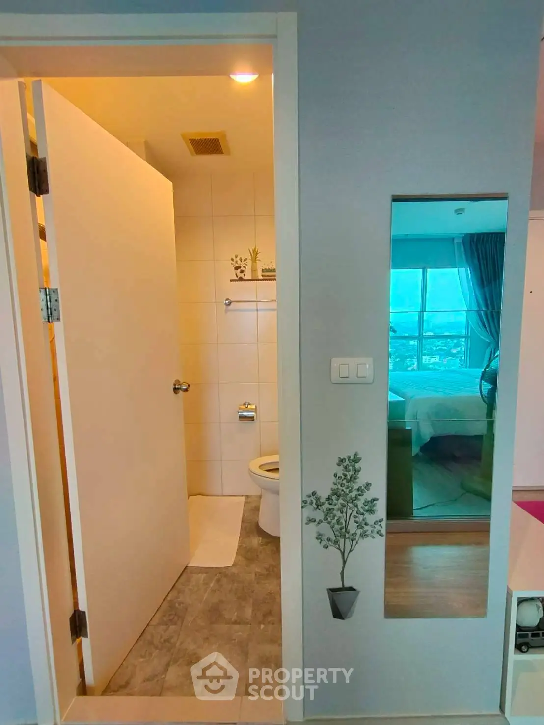 Modern apartment with bathroom and bedroom view, featuring sleek design and natural lighting.