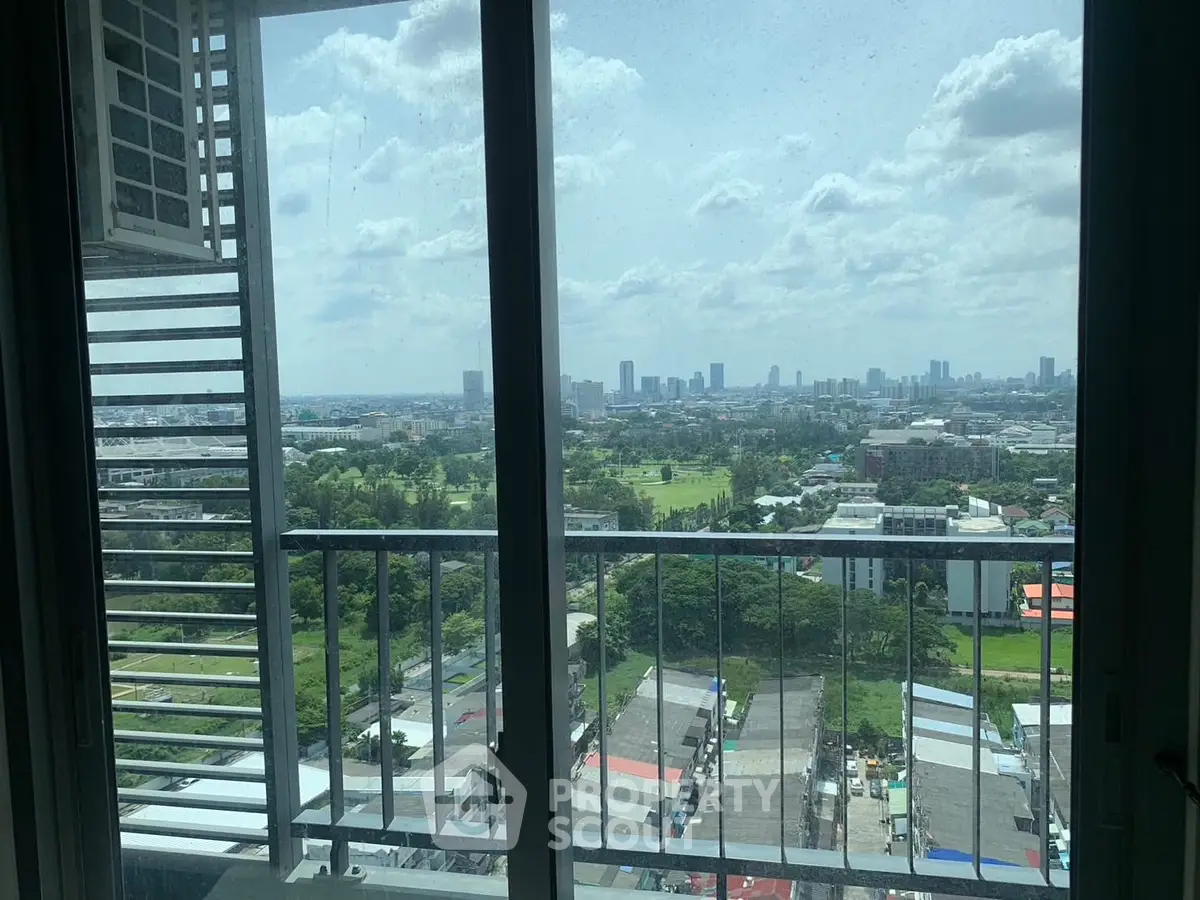 Stunning cityscape view from a high-rise balcony with lush greenery and skyline.