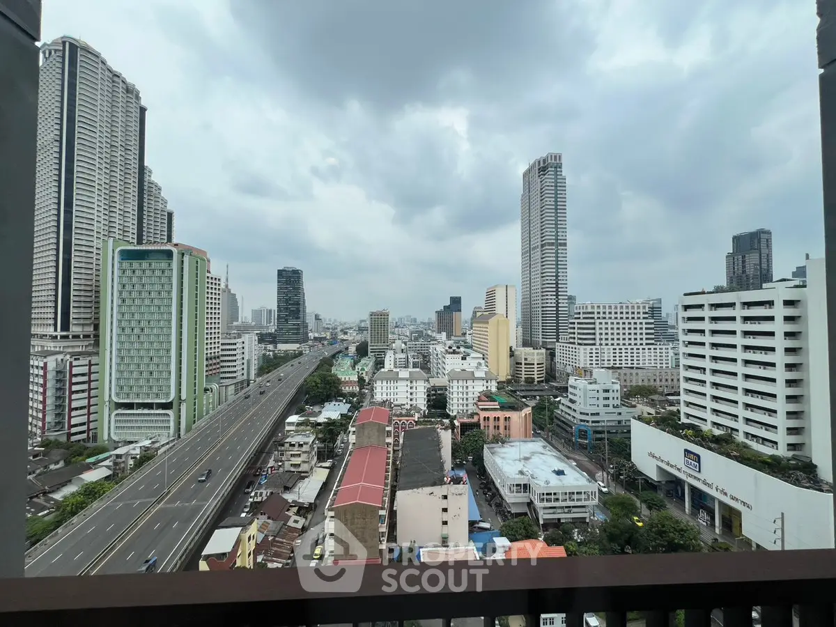 Stunning cityscape view from a high-rise balcony showcasing urban skyline and bustling streets.