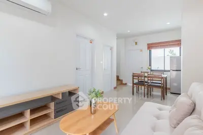 Modern living room with dining area, featuring sleek furniture and bright natural lighting.