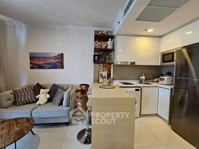 Modern kitchen with open layout and cozy living area, featuring sleek appliances and stylish decor.