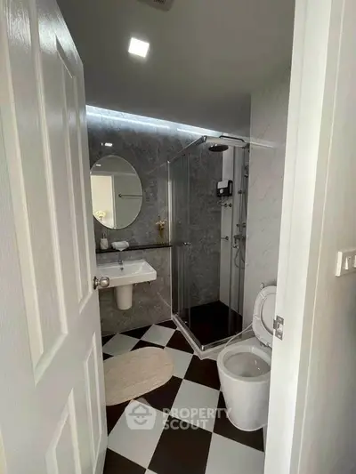 Modern bathroom with glass shower and checkered floor tiles