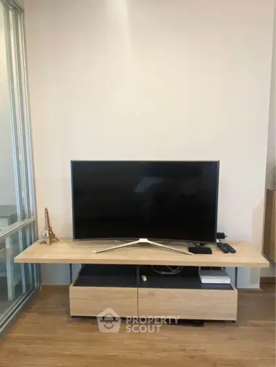 Modern living room with sleek TV stand and flat-screen TV, perfect for entertainment setup.