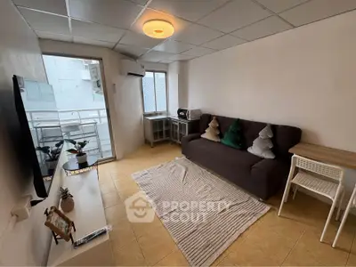 Cozy living room with modern decor and balcony access in urban apartment.