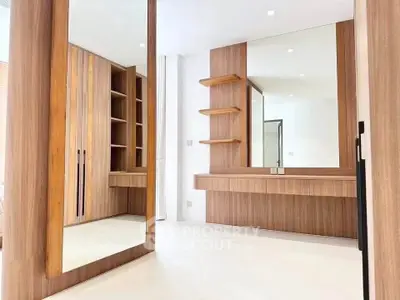 Luxurious walk-in closet with elegant wooden finishes and large mirrors