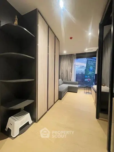 Modern living room with sleek design and city view, featuring stylish furniture and ample storage space.