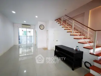 Spacious modern living room with sleek staircase and natural light