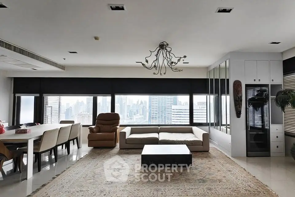 Spacious modern living room with city skyline view, elegant chandelier, and stylish furniture.