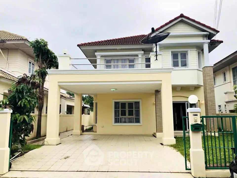 Charming two-story house with spacious driveway and lush greenery, perfect for family living.
