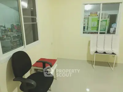Cozy small room with chair and window, ideal for a compact office or study space.