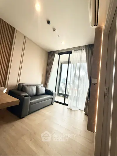 Modern living room with sleek sofa and city view balcony in high-rise apartment.