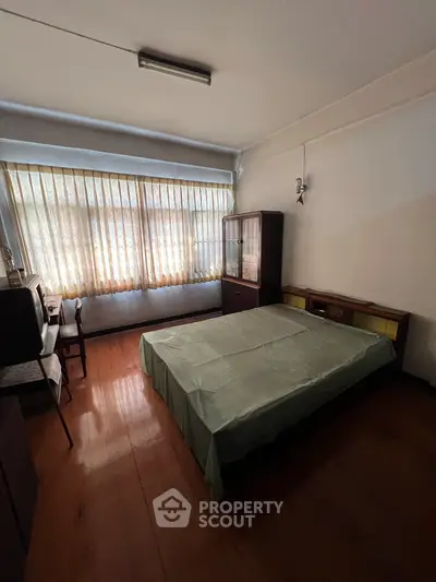 Cozy bedroom with natural light and vintage furniture, perfect for a restful retreat.