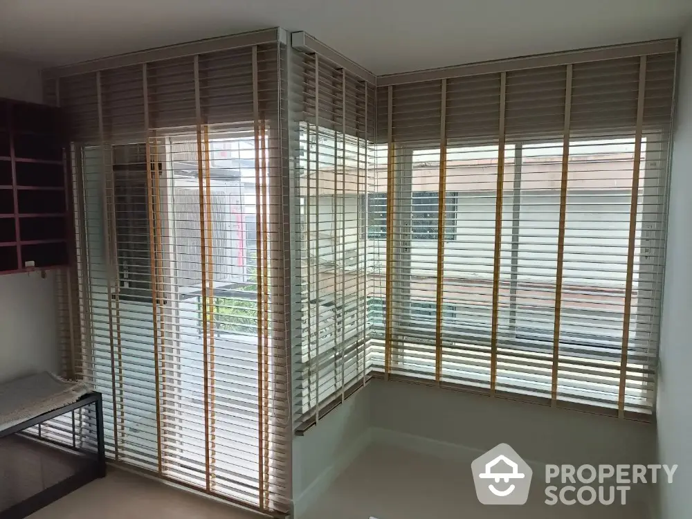 Modern corner unit with large windows and stylish blinds in a bright room.