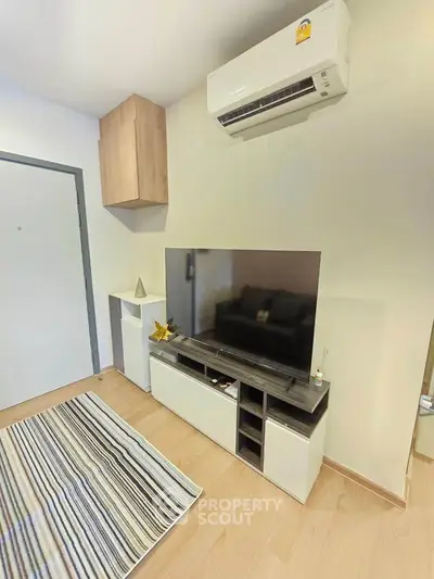 Modern living room with sleek TV unit and air conditioning, perfect for cozy entertainment.