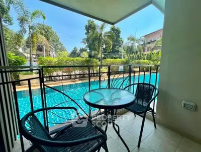 Charming balcony with pool view, perfect for relaxation and outdoor dining in a serene setting.
