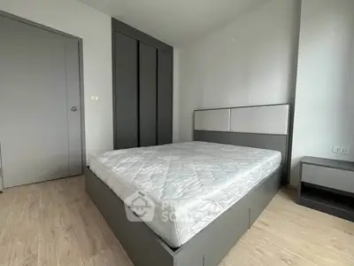 Modern minimalist bedroom with sleek gray furniture and comfortable mattress.