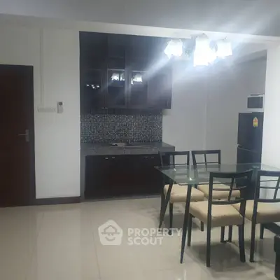Modern dining area with glass table and kitchen in open layout