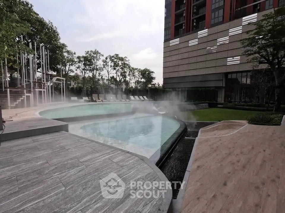 Luxurious modern pool area with sleek design and lush greenery in upscale residential complex.