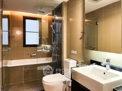Modern bathroom with glass shower and bathtub in stylish apartment.