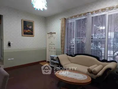 Elegant living room with classic sofa and large window, perfect for cozy gatherings.