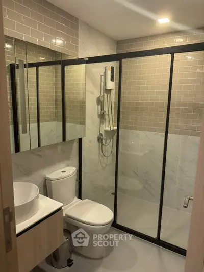 Modern bathroom with glass shower enclosure and sleek fixtures