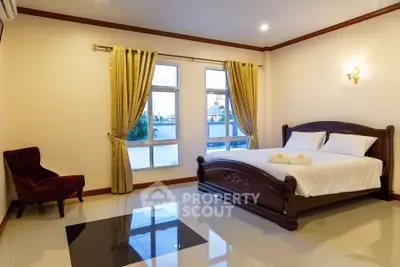 Spacious bedroom with elegant decor and large windows for natural light.