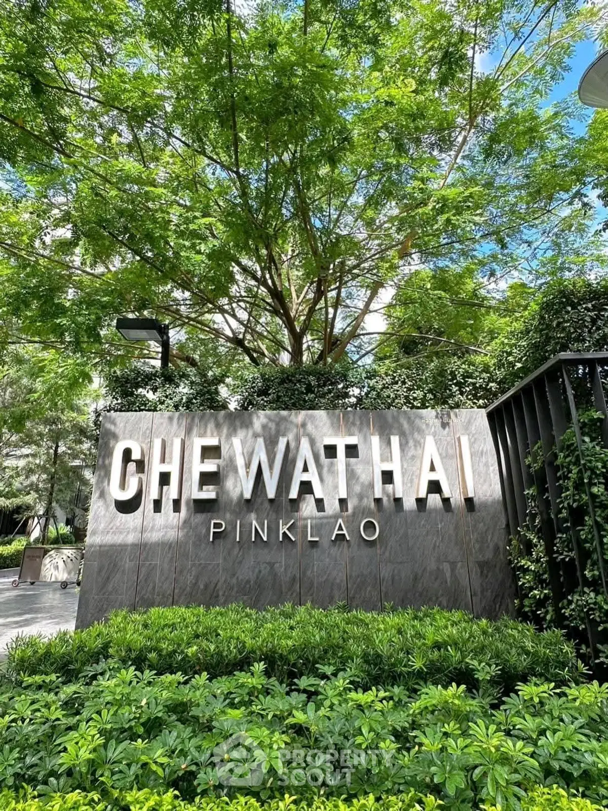 Modern building entrance with lush greenery and stylish signage at Chewathai Pinklao.