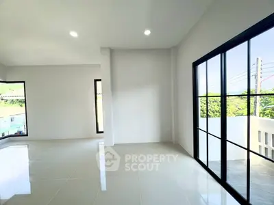 Spacious modern living room with large windows and natural light