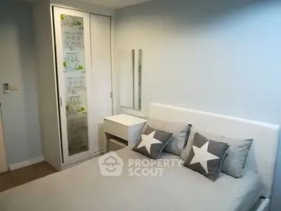 Cozy bedroom with stylish decor and ample storage in modern apartment.