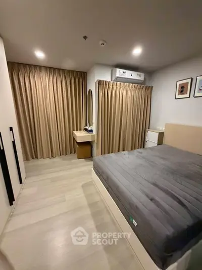 Modern bedroom with cozy lighting and elegant curtains, featuring a comfortable bed and stylish decor.