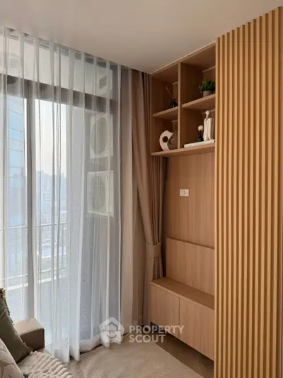 Modern living room with stylish wooden shelving and large window view.