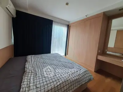 Spacious bedroom with modern design and large window for natural light.