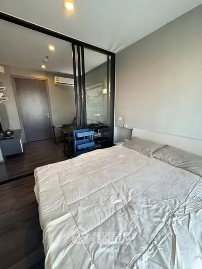 Modern bedroom with glass partition and cozy decor in a stylish apartment.