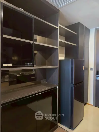 Modern kitchen with sleek black cabinets and stainless steel fridge