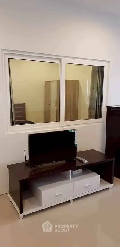 Modern living room with sleek TV stand and large window for natural light.
