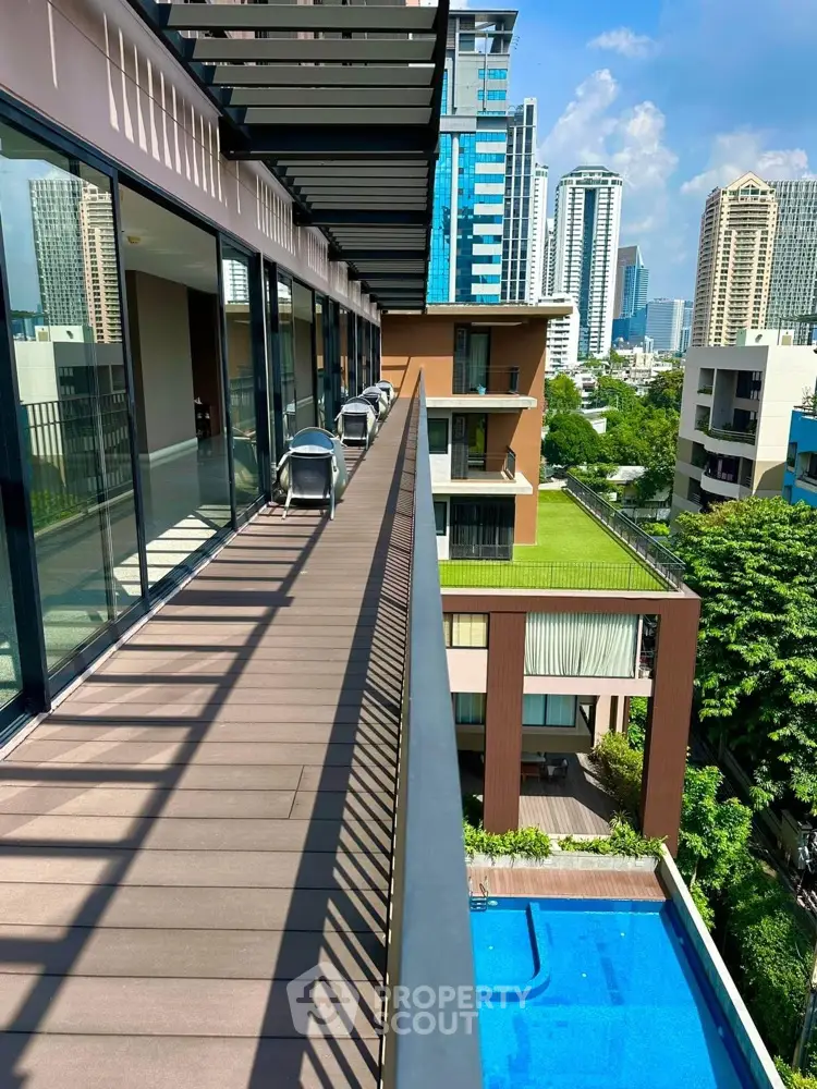 Modern urban balcony with stunning cityscape view and pool below