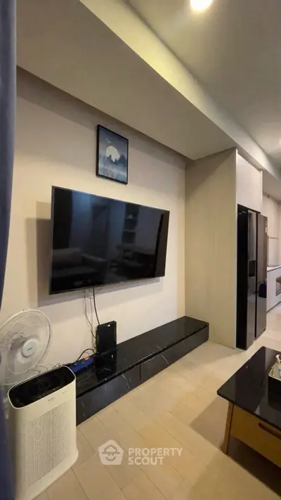 Modern living room with wall-mounted TV and sleek furniture