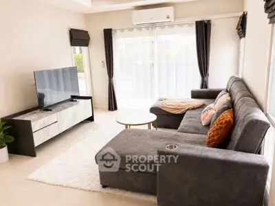 Spacious modern living room with plush sectional sofa and large TV, perfect for relaxation.
