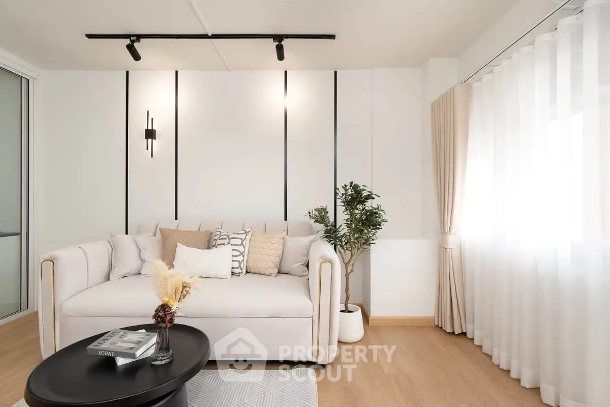 Modern living room with elegant sofa, stylish decor, and natural light creating a cozy ambiance.