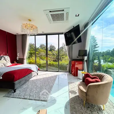 Luxurious bedroom with floor-to-ceiling windows offering stunning garden views, elegant decor, and modern amenities.