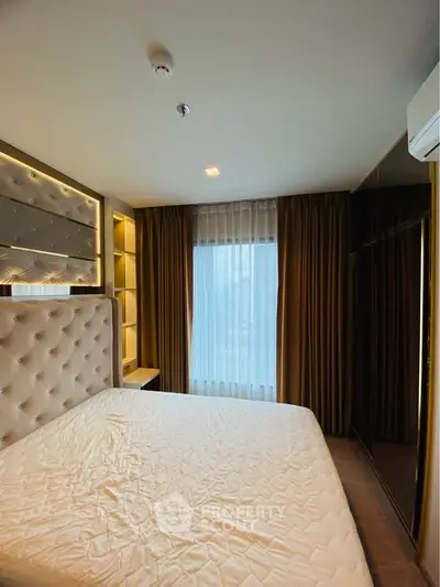 Luxurious bedroom with elegant headboard and large window for natural light.