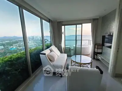 Luxurious living room with stunning ocean view and private balcony in high-rise apartment.