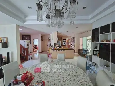 Spacious living room with elegant chandelier and open layout, perfect for family gatherings.