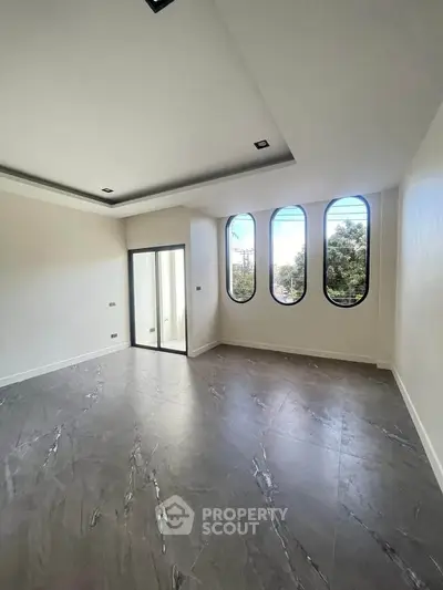 Spacious modern room with large windows and sleek flooring, perfect for a stylish living space.