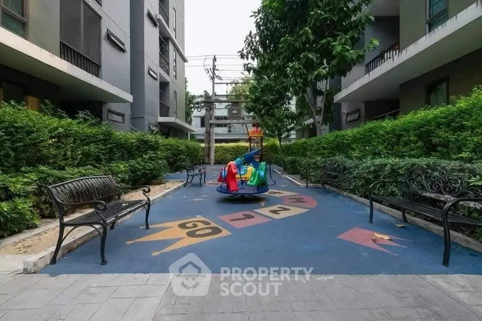 Charming residential courtyard with playground and benches, perfect for family living.