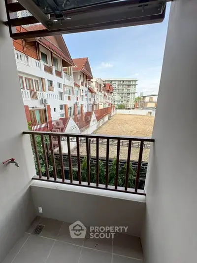 Charming balcony view overlooking residential buildings and open sky, perfect for relaxation.
